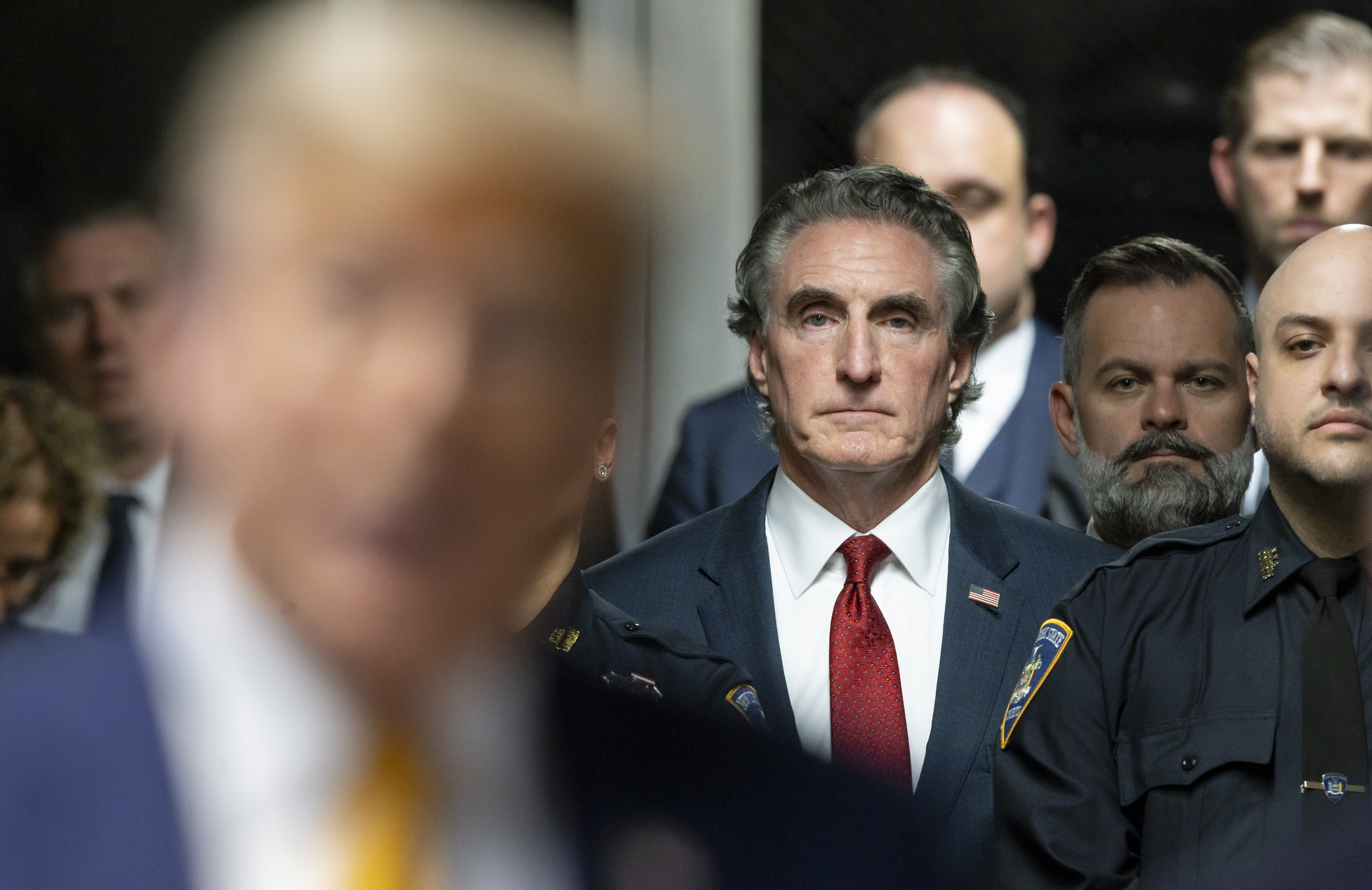 Republican North Dakota Gov. Doug Burgum listens as former President Donald Trump, in foreground, talks to reporters at Manhattan criminal court on May 14 in New York. Republican North Dakota Gov. Doug Burgum listens as former President Donald Trump, in foreground, talks to reporters at Manhattan criminal court on May 14 in New York.